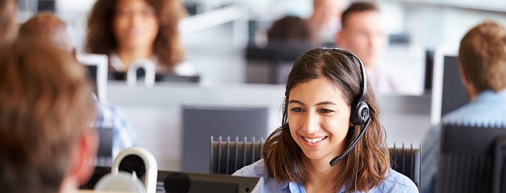 Young woman working in call centre, surrounded by colleagues | XPS Solutions Call Center Representative